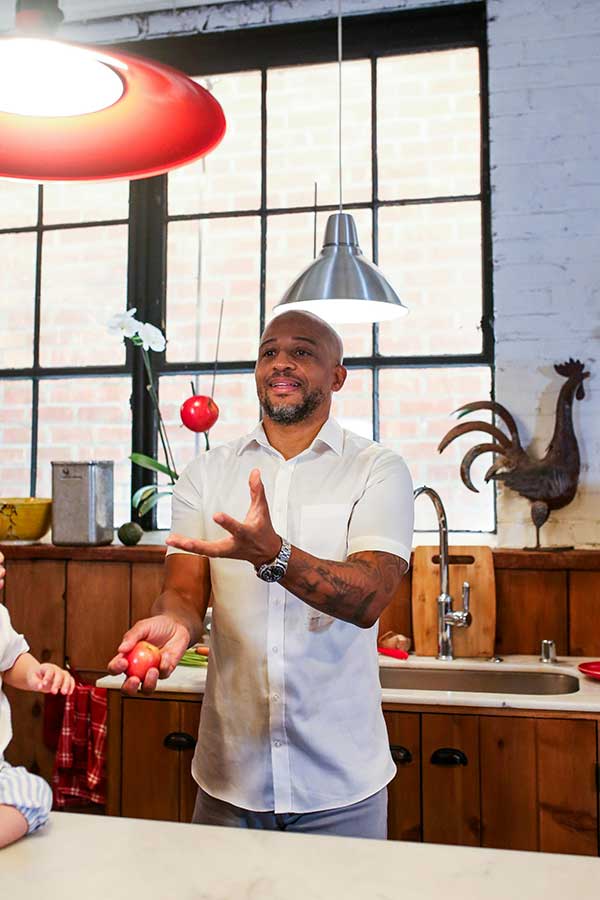 Man in a kitchen holding radishes, practicing mindfulness techniques in ADHD therapy.