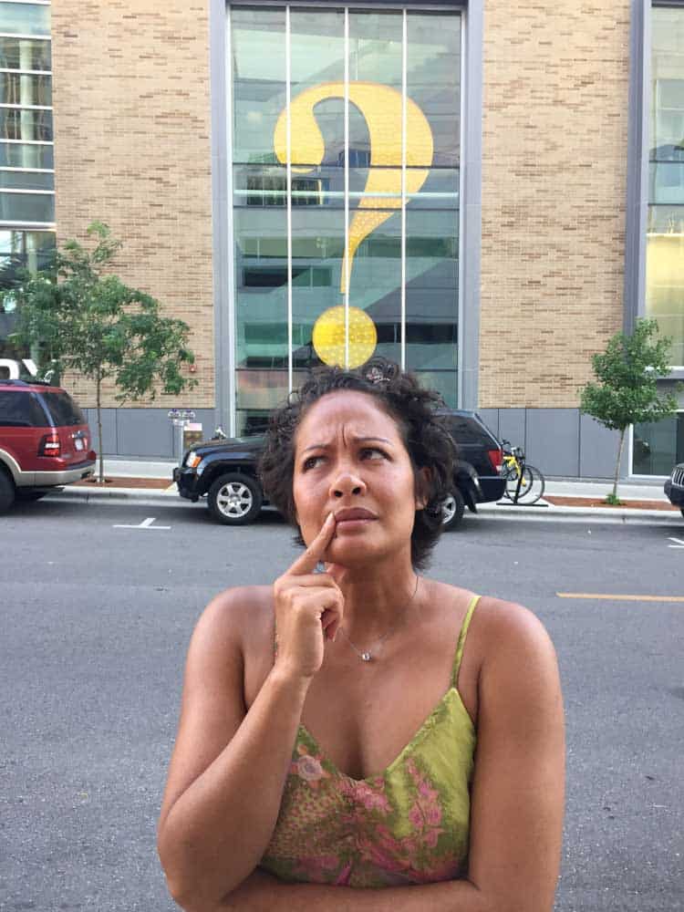 Woman contemplating with a question mark, looking for a life transitions therapist in Janesville, WI.