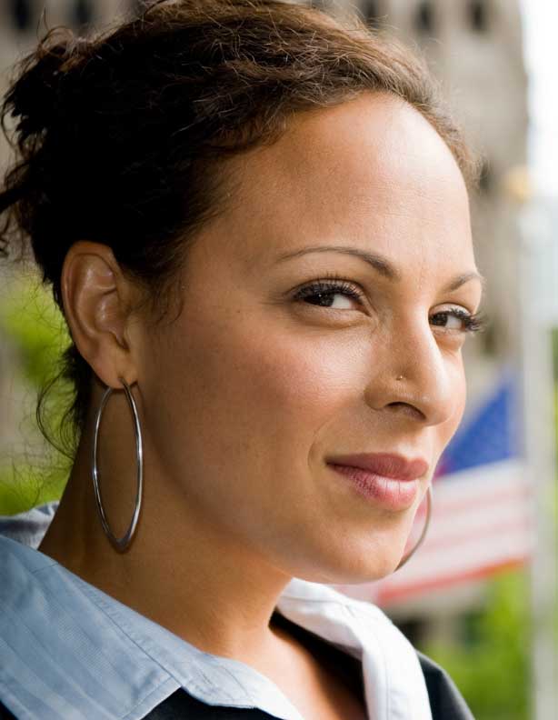 Confident woman smiling after consulting a trauma therapist, feeling empowered and renewed.